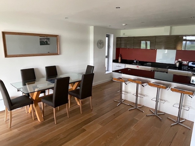 Open plan dining and living area with views across Newquay golf course and the surf of Fistral Beach, Cornwall